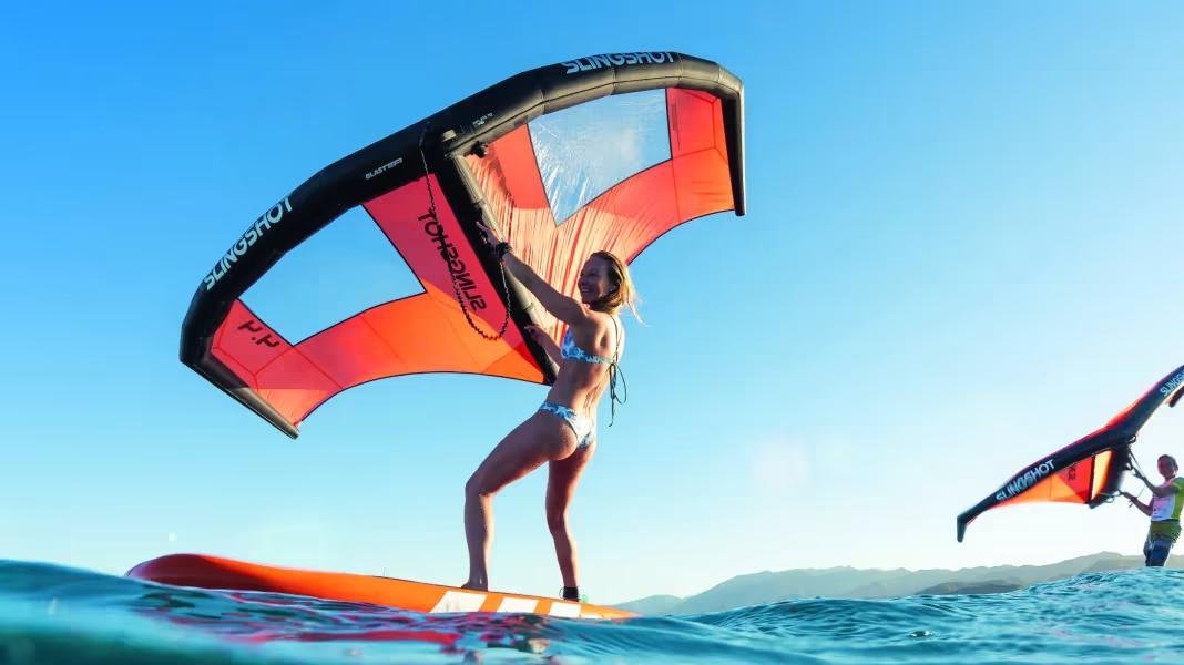 Тётя на САПе с вингом,  фоточка из статьи https://www.surf-magazin.de/en/sup/how-to/driving-technique/tutorial-learning-to-wingsurf-on-the-sup-from-paddle-to-wind-sport/<br>
